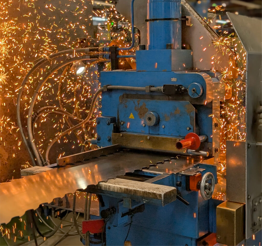 Welding a band saw blade with sparks in a manufacturing workshop.