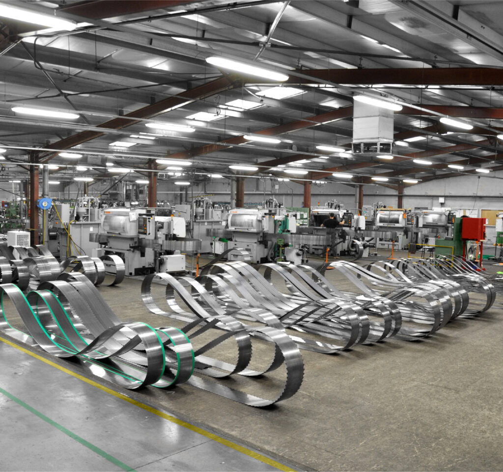 Steel band saw blades, carefully wound and stored in a modern industrial workshop.