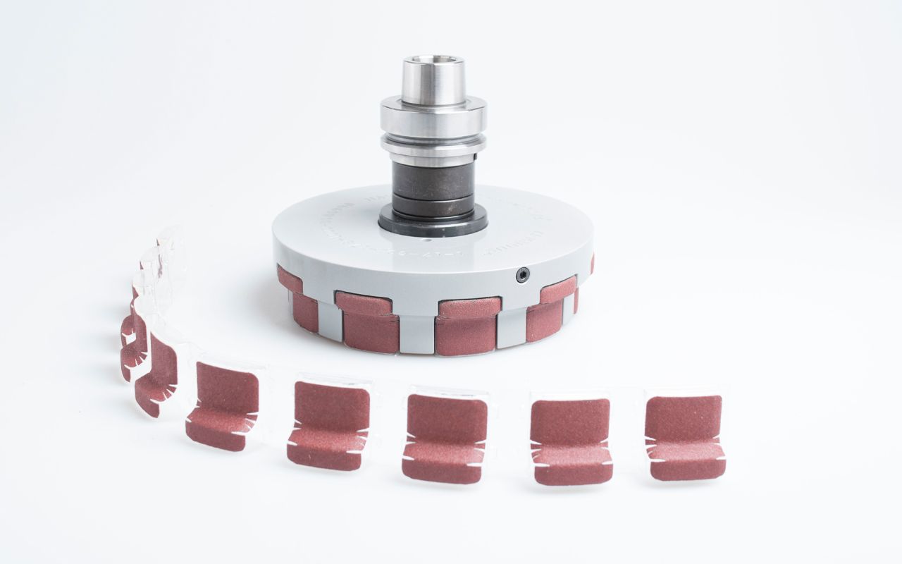 Arminius abrasive sanding tool with belt inserts mounted on platen